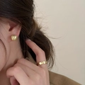 Orecchini a sfera dorati opachi e anello lucido indossati da una modella elegante - 10mm / Oro