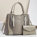 Detail of grey crocodile embossed patent leather handbag set with gold hardware accessories - Gray
