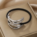 Detailed side view of multi-layer silver metal hair ring on champagne silk surface - Silver Double Layer Hollow