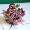 Detail view of dusty mauve silk roses and peonies bouquet on a decorative book - Purple