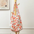 Detail of floral canvas tote bag hanging on a wooden hanger in a cozy home setting - Pink Purple Small Flower