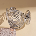Dettaglio macro di un bracciale a spirale argento su pietra con ombre artistiche - Argento