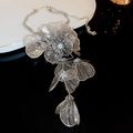 Detail of silver floral necklace featuring intricate metal weaving and dangling leaf charms - Silver