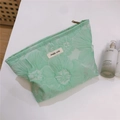 Detailansicht der minzgrünen Kosmetiktasche mit floraler Textur und Stoffetikett - Grüne Geprägte Große Blüte