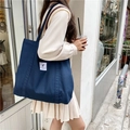 Deep blue canvas tote bag showing on-shoulder size perspective in daily street scene - Navy Blue