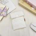 Détail de la pochette matelassée blanche à motifs cœurs avec bouton pression sur bureau - Cœur Blanc