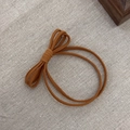 Brown elastic bow hair tie with fabric texture on a natural linen background - Red Brown