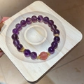 Macro shot of amethyst beaded bracelet with gold accents on a wooden tray detail - Natural Amethyst Strawberry Quartz