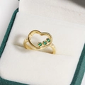 Nahaufnahme eines vergoldeten Herzrings mit grünen Zirkonia auf Samtuntergrund - Goldener Grüner Zirkon