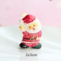 Macro-opname van 2x3cm Kerstman hars accessoire met rode en witte glitter details - Aanmoedigende Kerstman