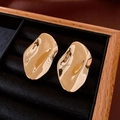 Primer plano de pendientes dorados irregulares en terciopelo negro en un joyero de madera - Superficie de Onda Irregular (Pin de plata-Dorado) / Dorado