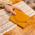 Slim yellow pebble leather envelope wallet shown in hand for professional style - Yellow
