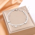 Elegant silver double-layer chain bracelet featuring star charms on a luxury jewelry box - Silver
