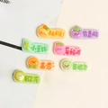 Close-up of cute resin charms with colorful Chinese phrases and cartoon designs - Fruit Homophonic Word Plate