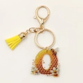 Detail of acrylic letter O keychain with honeycomb pattern, bee motif and yellow tassel - Letter O