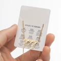 Gold stainless steel Angel Number 777 pendant necklace shown on informative display card - Cutout 777 / Gold