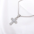 Elegant silver cross necklace featuring sparkling red and clear crystals on silk fabric - White