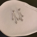 Boucles d'oreilles argentées avec perle et chaîne à pompon sur un plateau blanc texturé - Argent (Tige en argent)