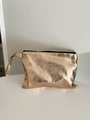 Close-up of golden snakeskin texture and metal zipper on a luxury cosmetic bag - Rose Gold Snake Pattern