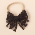 Close-up of black lace bow headband with intricate embroidery on elastic nylon band - Black