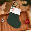 Green knit Christmas stocking with embroidered red letter J on white cuff in rustic tray - Letter J