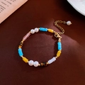 Détail d'un collier de perles multicolores avec perles d'eau douce et fermoir doré - Style Perlé de Perles d'Œil de Tigre