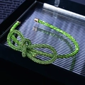 Close-up of a sparkling green rhinestone bow necklace displayed in a dark gift box - Knotted Full Green Rhinestone Slim Headband