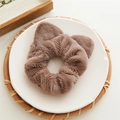 Brown plush cat ear scrunchie on white tray for minimalist hair styling accessory - Brown
