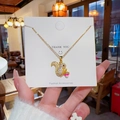 Gouden eekhoorn ketting met zirkoon inleg die een roze noot vasthoudt op een kaartje - Goud Eekhoorn