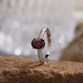 Macro shot of oval red garnet ring in silver with pavé-set clear accents and open band - Natural Garnet Eternity Ring LR394