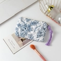 Close-up of quilted floral cosmetic bag with blue flower patterns and purple zipper puller - Dark Blue Floral
