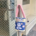 Dettaglio della borsa a secchiello in tela con coniglio cartoon e manico in peluche rosa - Coniglio di Cola