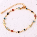 Dettaglio di un bracciale dorato con ciondoli a forma di occhio greco smaltato colorato - Bracciale Occhio del Diavolo Rotondo
