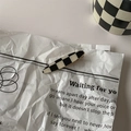 Retro black and white checkerboard hair clip displayed on a minimalist lyric paper background - 18# Duckbill Clip - Oval