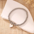 Bracciale alla moda con perline e ciondolo a cuore argento su espositore in pietra - Argento