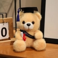 Plush graduation bear with black cap and Congratulations sash in light brown fur - Deep Blue Sash Style / Tan