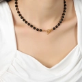 Collier vintage en perles d'agate noire avec fermoir à bascule doré porté par un mannequin - Moyen (Diamètre des perles env. 0,6 cm)