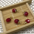 Five red teardrop stone pendants with gold metal plating on a bamboo tray - No.25 Bright Red Stone