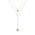 Détail d'un collier double rang doré avec pendentif en pierre rouge et breloque pois - Pierre Naturelle Rose Jaune