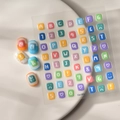 Vista macro di adesivi per unghie 3D con lettere e numeri colorati su vassoio bianco - Stile Alfanumerico (CO-009)
