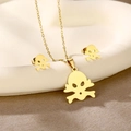 Macro shot of gold skull necklace and earring set in a ceramic display bowl - Skull (TZ-452)