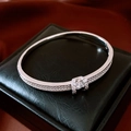 Vista macro detallada del brazalete bañado en plata 18K con circonitas y piedra central brillante - Plateado
