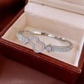 Close-up of a silver hollow gourd bangle with pave diamonds in a premium jewelry box - Silver