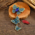 Exquisite gold butterfly brooch with blue and turquoise crystals on a natural wood base - Blue