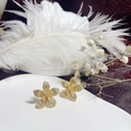 Close-up of gold flower stud earrings with sparkling rhinestones on a decorative tray - Gold Flower