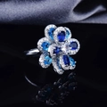 Detailed view of silver flower ring with blue and clear zircon stones on grey silk - Adjustable Ring