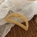 Elegant beige semi-circular hair claw clip with golden spring on textured paper - Beige
