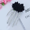Gothic skull hand hair clip with black roses detail on a stylized artistic background - Black Twin Flowers / Black