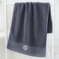 Dark grey cotton towel with elegant golden crown S embroidery hanging on a white rack - Cotton Crown Grey (Towel)