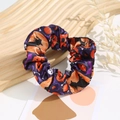 Detail of purple satin Halloween scrunchie with skull, pumpkin, and bat prints on wood - Halloween #5 (Light Purple Festive Mix)